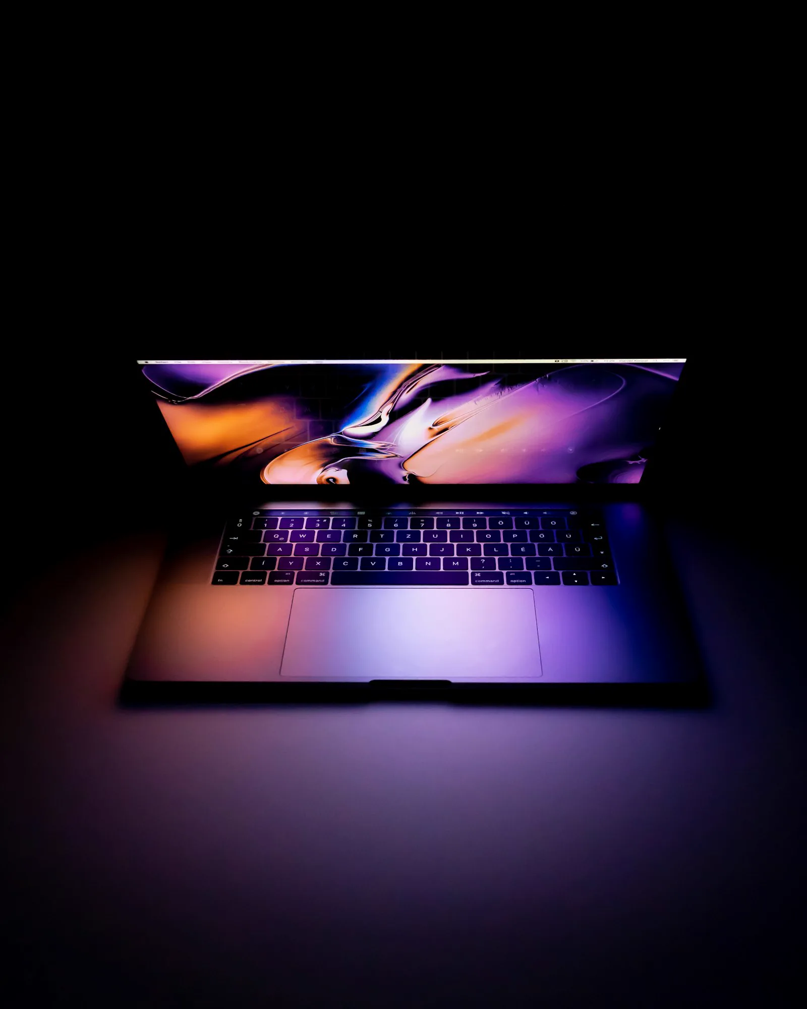 Notebook com luz neon sobre mesa preta